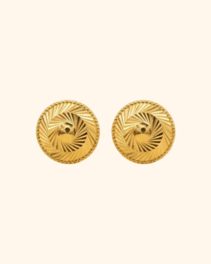 Gold stud earrings on studio background
